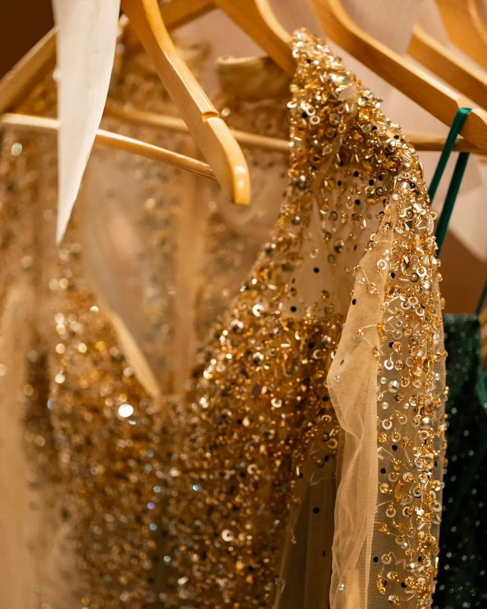 A gold sequinned party dress on a hanger