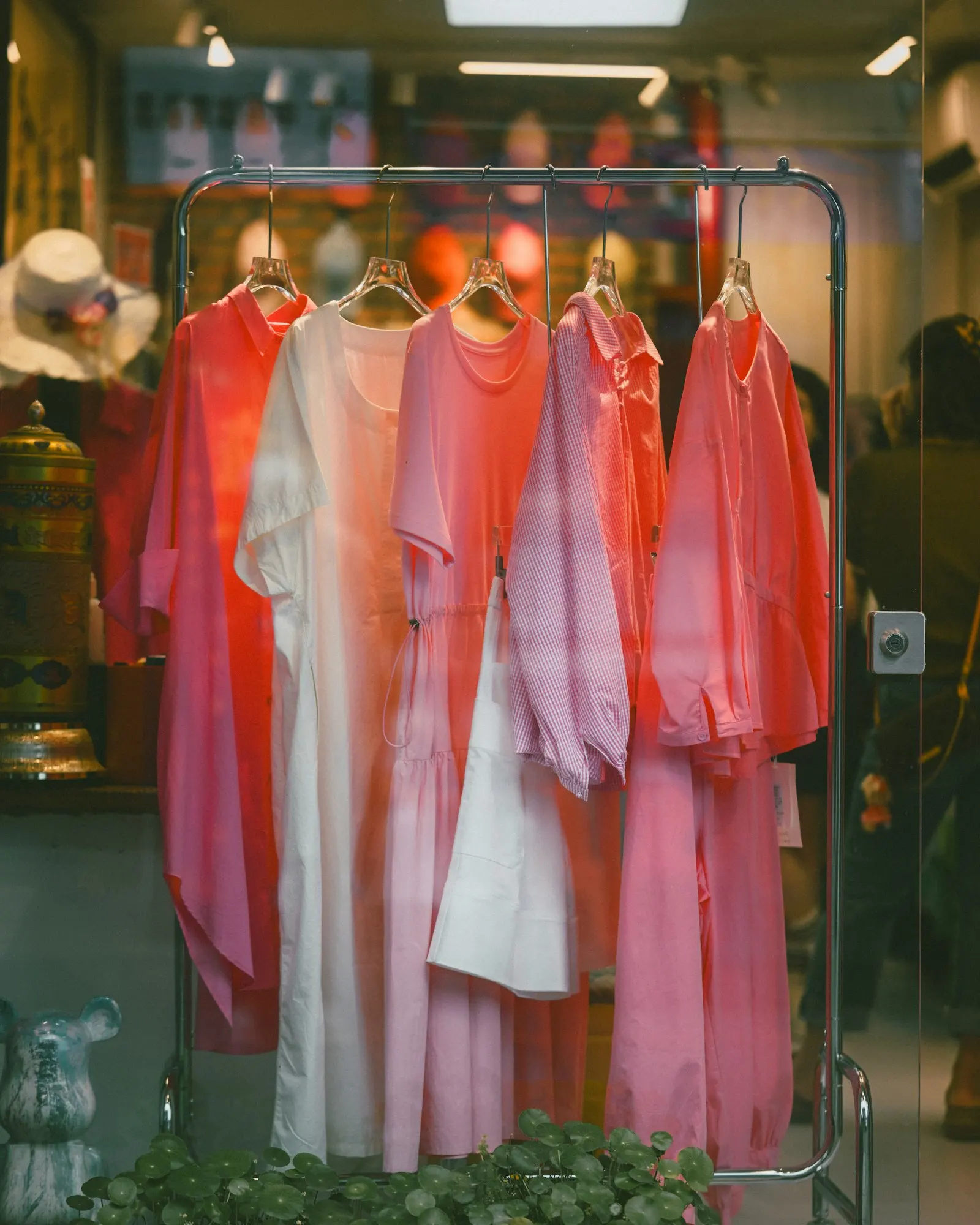 Pink and white clothing on a rack in a shop window