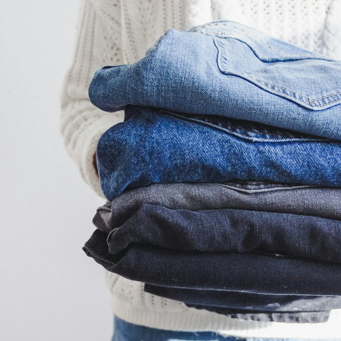 Hands holding a folded stack of vintage denim