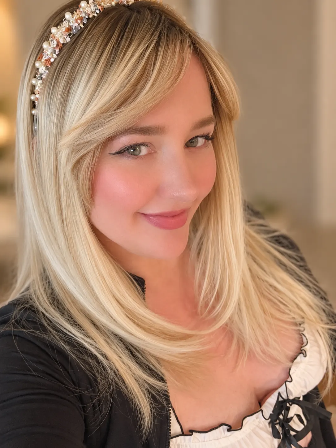 Rachel, founder of Raychella Co, in a pearl headband and a black cardigan over a white top